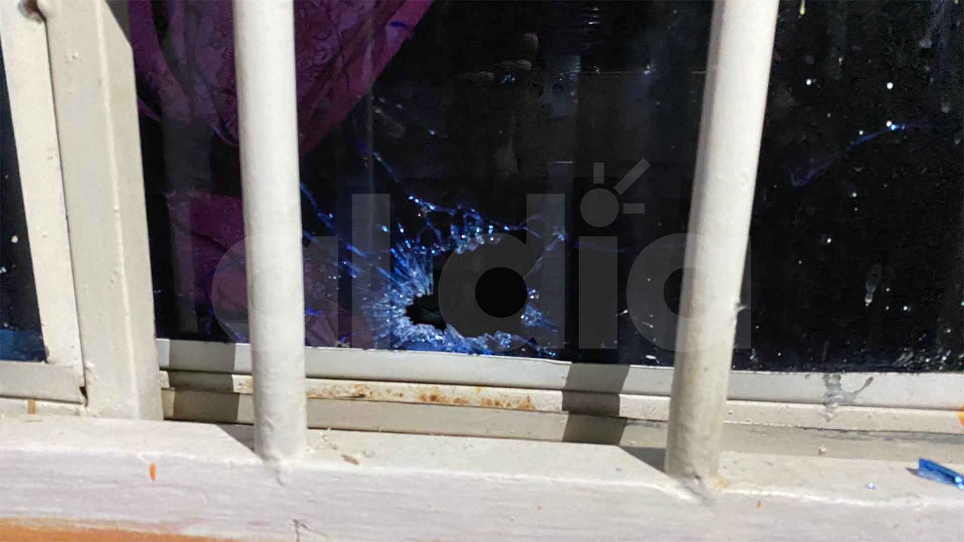 Aspecto del agujero que dejó en la ventana el paso de uno de los proyectiles de arma de fuego