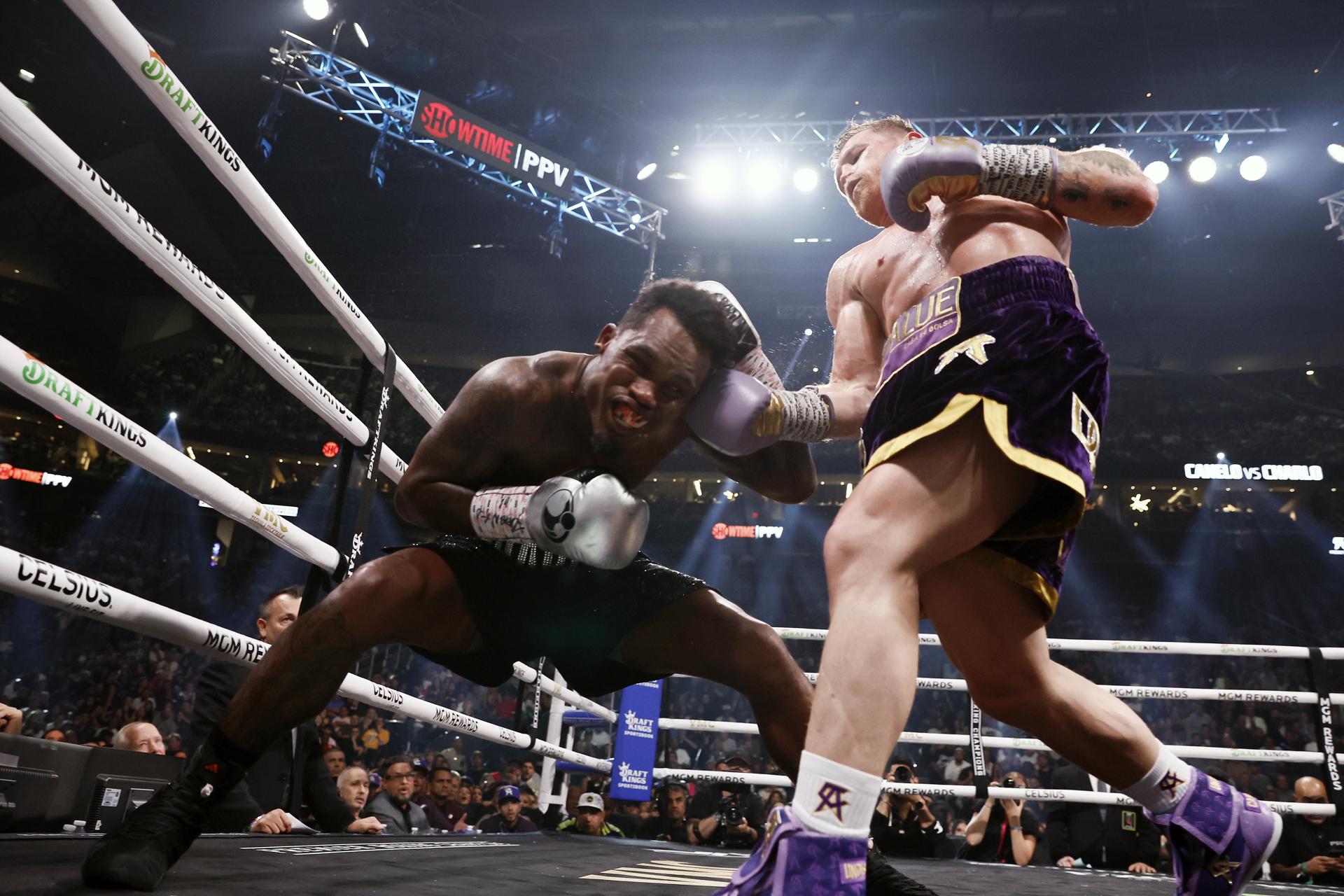 Canelo Álvarez propinando un fuerte golpe a Jermell Charlo en su cuerpo