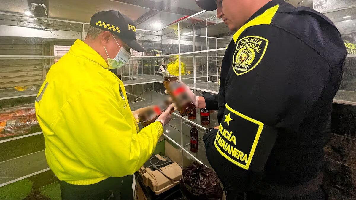 Autoridades decomisando botellas de whisky ilegal.