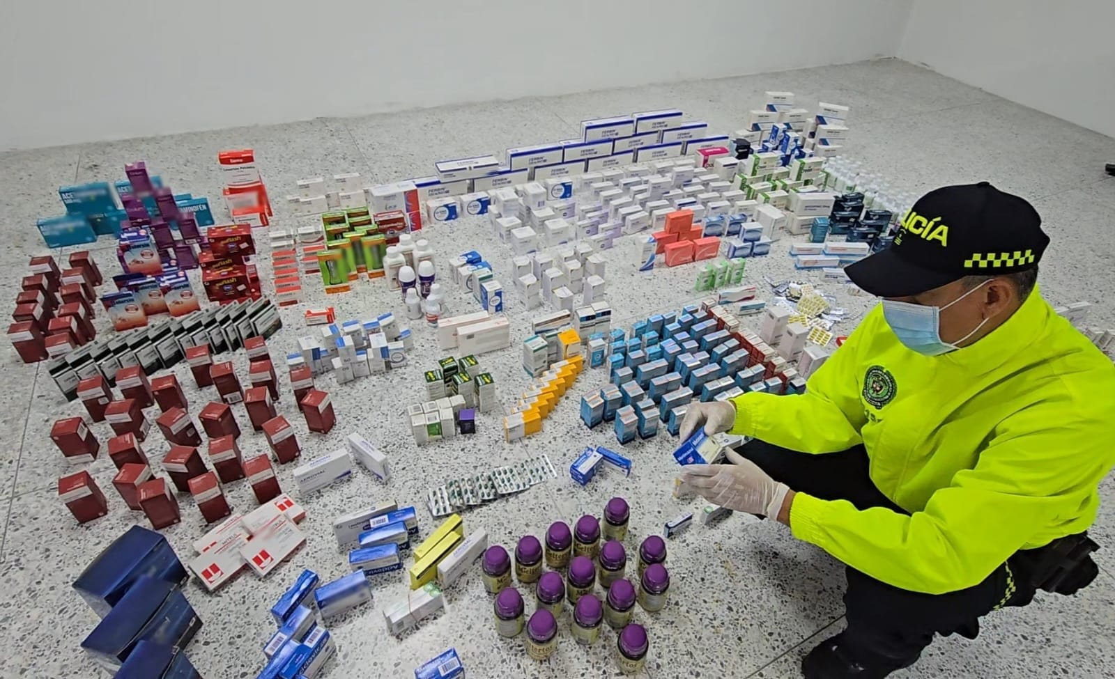 Policía con medicamentos incautados.