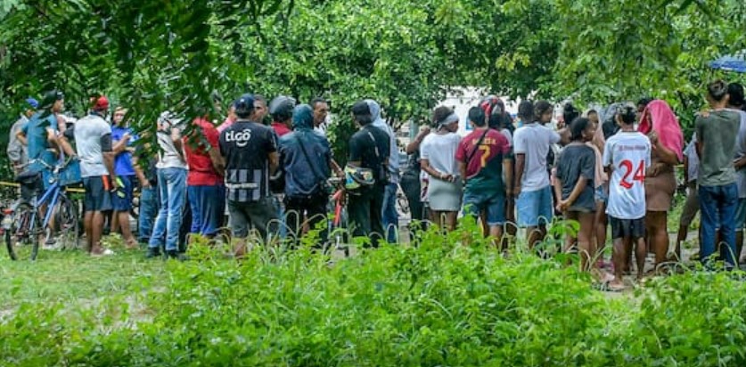 Personas observando un cadáver.