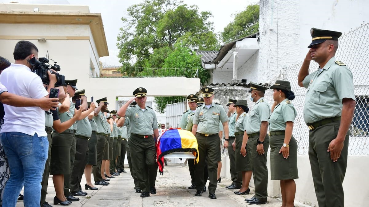 Los oficiales Edwin Urrego y John Peña cargan el féretro con los restos del patrullero José Daniel Valera Narváez.