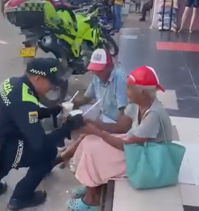 Momento en que el patrullero da de comer a los abuelitos