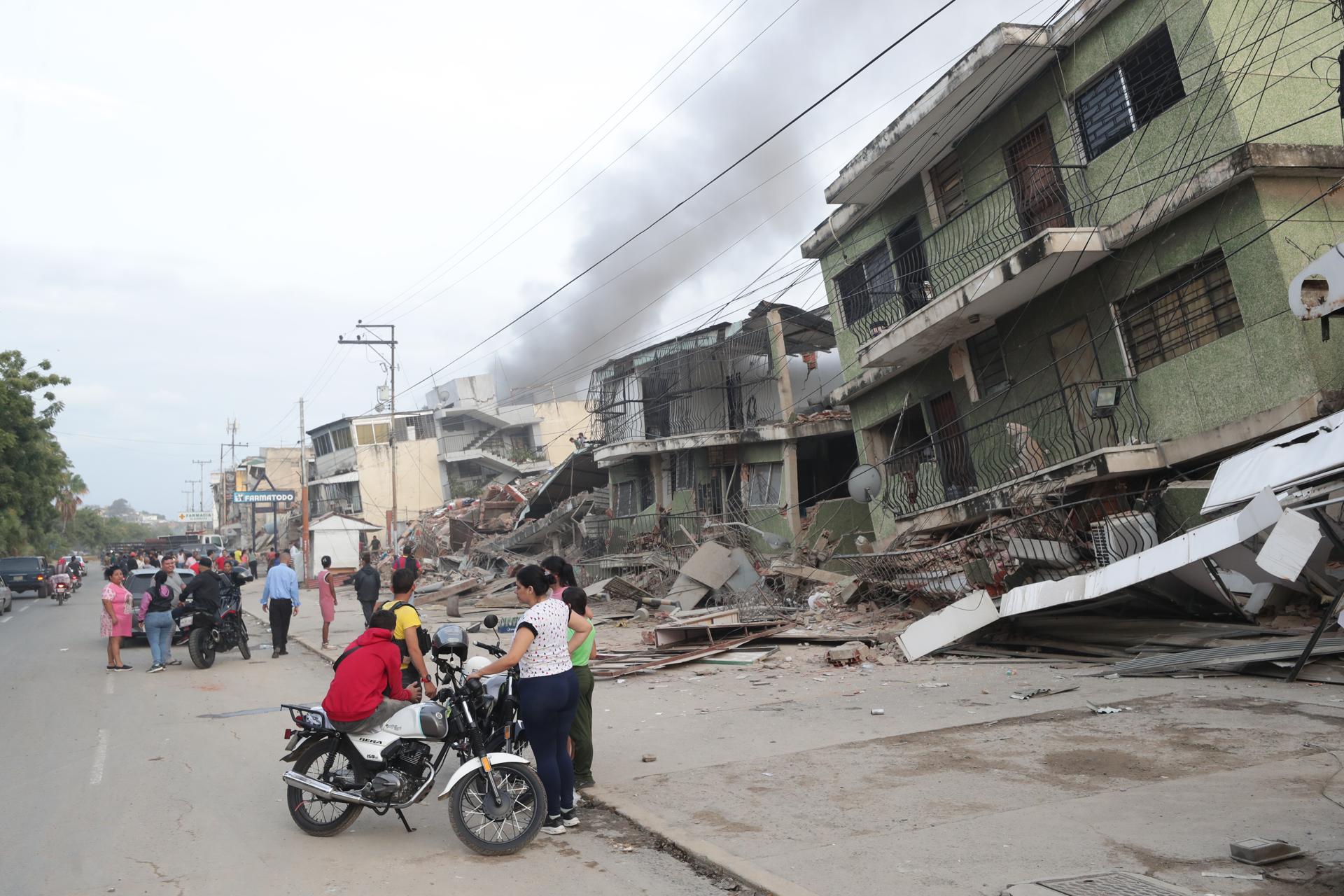Residentes permanecen en la calle junto a varios bloques de viviendas dañados por los terremotos