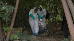 Agentes realizando el levantamiento de un cuerpo. 