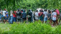Personas observando un cadáver.