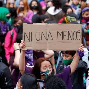 Una mujer levanta una pancarta para la no repetición de hechos violentos contra la mujer