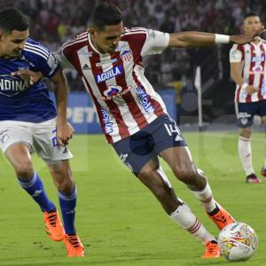 Homer Martínez, mediocampista de Junior, disputa un balón en el mediocampo con Stiven Vega, de Millonarios