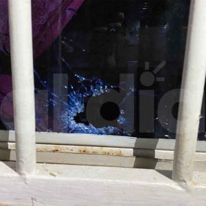 Aspecto del agujero que dejó en la ventana el paso de uno de los proyectiles de arma de fuego