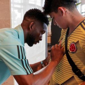 Jefferson Lerma le da un autógrafo a un aficionado colombiano en el sitio de concentración de la Selección en España.