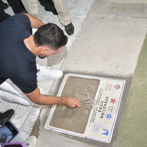 Sebastián Viera estampando sus manos en la placa de cemento.