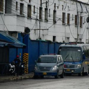 Dos vehículos del Inpec permanecen estacionados en la entrada de la Cárcel Modelo de Barranquilla, en la vía 40.