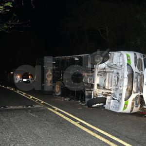 El bus volcado a un lado de la carretera tras el trágico hecho