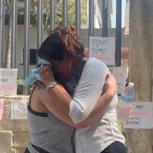 La madre abrazada a una amiga durante una manifestación a las afueras de Medicina Legal