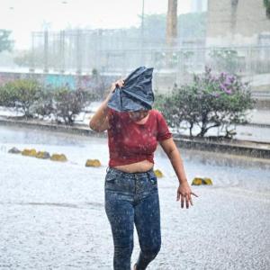 Una mujer se cubre del agua con un abanico manual