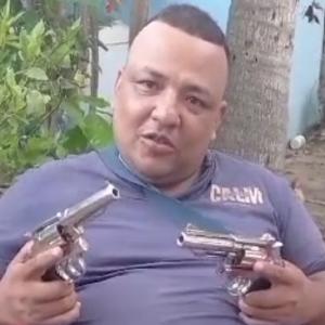 Uno de los extorsionistas muestra armas de fuego a lo largo de su amenaza