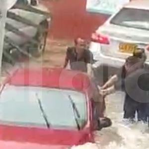 Momento en que varias personas auxilian a los tripulantes de un carro