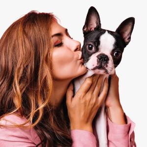 Mujer besando a su mascota, un perro.