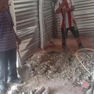 Vecinos rompiendo el piso de la vivienda de Loma Roja.