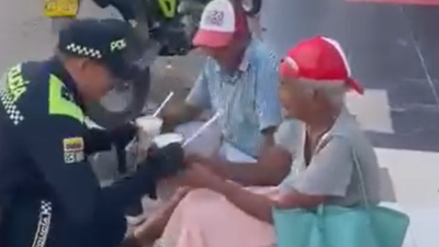 Momento en que el patrullero da de comer a los abuelitos