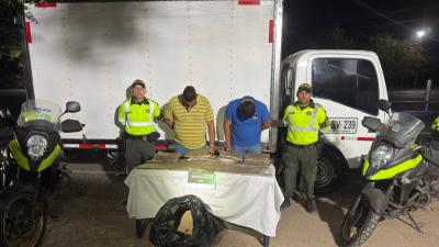Dos hombres capturados junto con el estupefaciente incautado.
