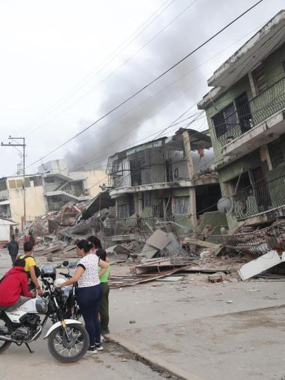 Residentes permanecen en la calle junto a varios bloques de viviendas dañados por los terremotos