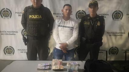 El capturado con el dinero incautado.