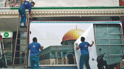 El momento en el que trabajadores de Tierra Santa retiran una valla publicitaria. 