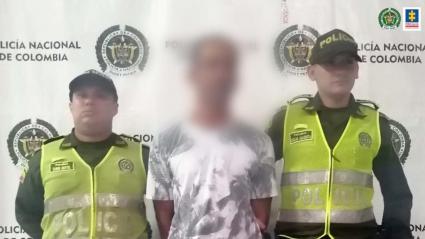 Uno de los capturados acompañado por agentes de la Policía. 