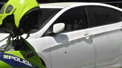 un vehículo de color blanco resultó afectado por las balas de los sicarios que, al parecer, tenían la intención de atentar contra un establecimiento comercial