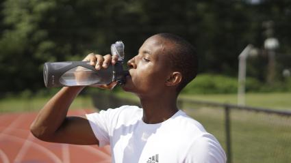 Un joven hidratándose tras una jornada de ejercicio