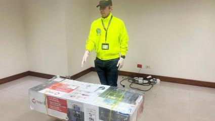 Policía con el armamento incautado en el Aeropuerto Ernesto Cortissoz.