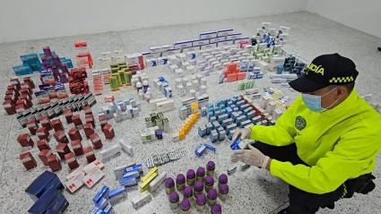 Policía con medicamentos incautados.