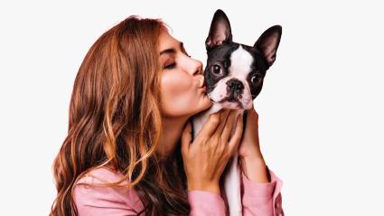 Mujer besando a su mascota, un perro.