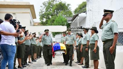 Los oficiales Edwin Urrego y John Peña cargan el féretro con los restos del patrullero José Daniel Valera Narváez.