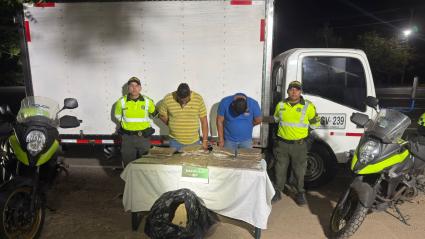 Dos hombres capturados junto con el estupefaciente incautado.