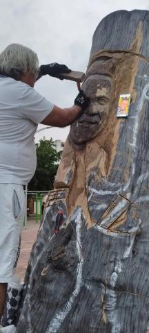 Pedro Ortega tallando busto de Omar Geles en madera.